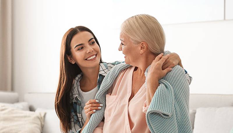 A caregiver embracing a senior at home