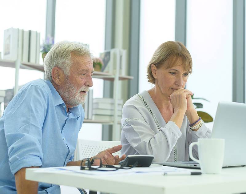 A retired couple reviewing their savings together at the kitchen table