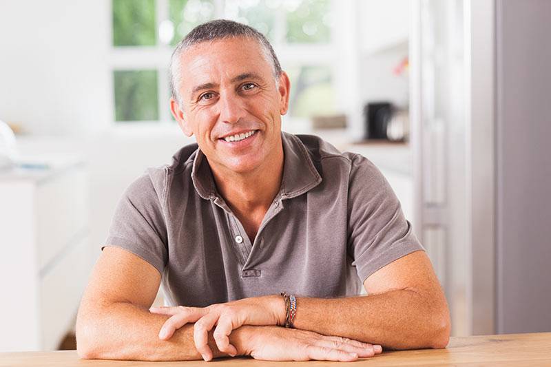 A man in his 60s sitting at his kitchen table